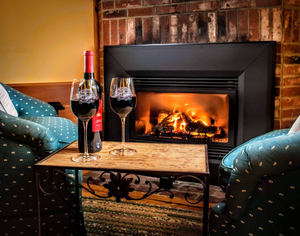 Picture of fireplace with wine glasses in foreground.